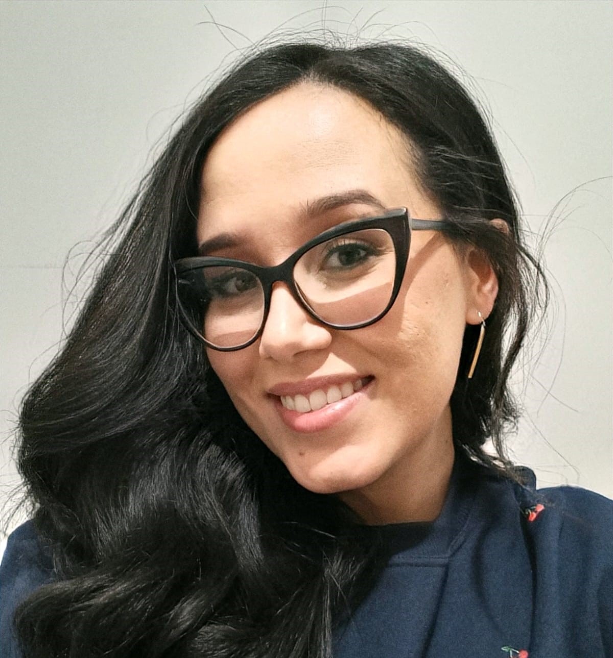 Retrato de Maria Cecília sorrindo, usando óculos cat-eye